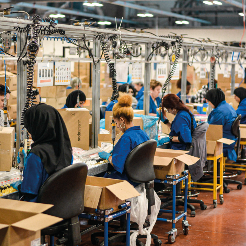 Factory workers packaging items in a busy warehouse.