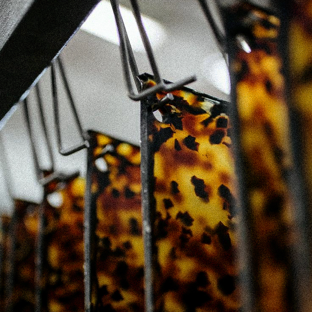 Close-up of a tortoiseshell patterned product with metal bars in the foreground